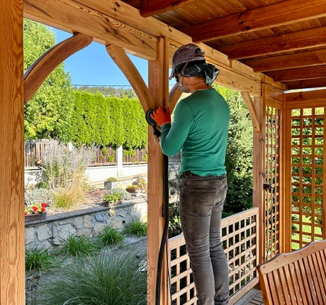 Patios Dallas craftsman installing custom wooden pergola structure for outdoor living space in Dallas TX